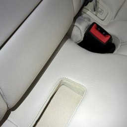 Brand New Car - Jasna skórzana tapicerka samochodowa z widocznymi pasami bezpieczeństwa i mocowaniami ISOFIX