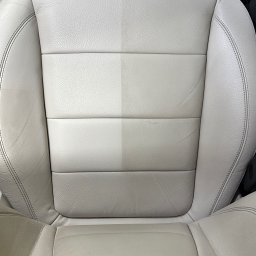 Brand New Car - Jasna skórzana tapicerka samochodowa, widoczna różnica w czystości po lewej stronie, ukazująca efekt prania
