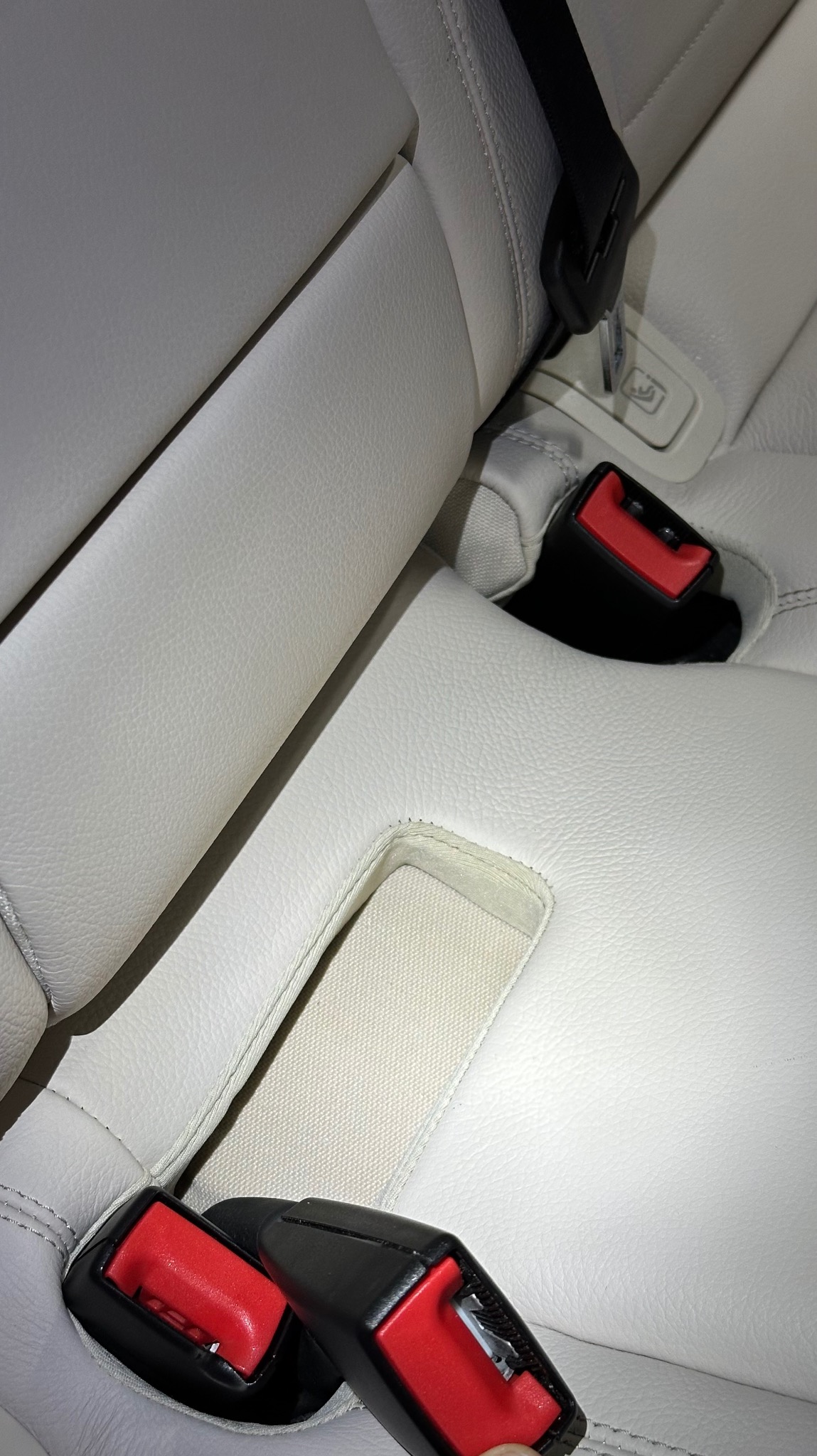 Jasna skórzana tapicerka samochodowa z widocznymi pasami bezpieczeństwa i mocowaniami ISOFIX