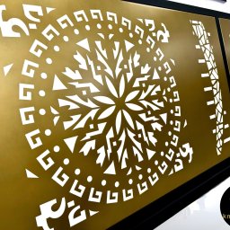 KM Design DOMINIKA KORYCIŃSKA - Dekoracyjne panele metalowe z wycinanym wzorem, złoty kolor, nowoczesny design. Realizacja z Koszalina.