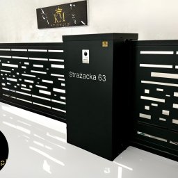 KM Design DOMINIKA KORYCIŃSKA - Nowoczesna, przesuwna brama wjazdowa z czarnymi, metalowymi panelami o ażurowym wzorze, zintegrowana ze skrzynką na listy z adresem 'Strażacka 63'.