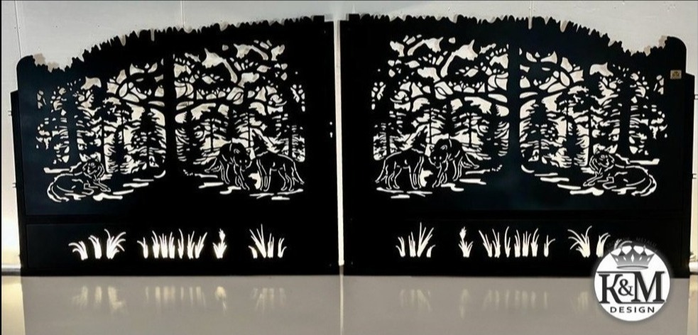 Metalowa brama wjazdowa z laserowo wycinanym motywem leśnym: wilki, drzewa i trawy, prezentowana w studiu z odbiciem na błyszczącej powierzchni.
