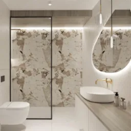 Elegancka łazienka z kabiną prysznicową typu walk-in, marmurowymi płytkami, owalnym lustrem z podświetleniem LED, białą umywalką nablatową z złotą baterią i minimalistyczną toaletą podwieszaną.