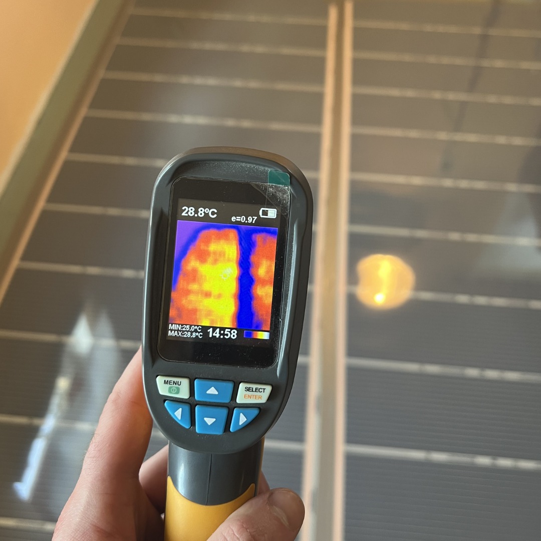 Termowizja podłogowej instalacji grzewczej, widok z kamery termowizyjnej na rozłożone przewody grzewcze w podłodze, na ekranie kamery widoczny rozkład temperatur.