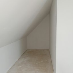 D&P-BUD Łapiński Patryk - Poddasze z widoczną skośną ścianą, przygotowane do ocieplenia, surowy beton na podłodze.