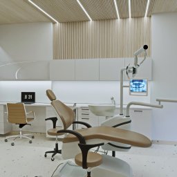 Yurii Fedenko Solutions - Wnętrze gabinetu dentystycznego z beżowym fotelem dentystycznym, lampą, monitorem z prześwietleniem zębów, białymi szafkami i biurkiem z laptopem wskazującym godzinę 8:31. Drewniane panele...