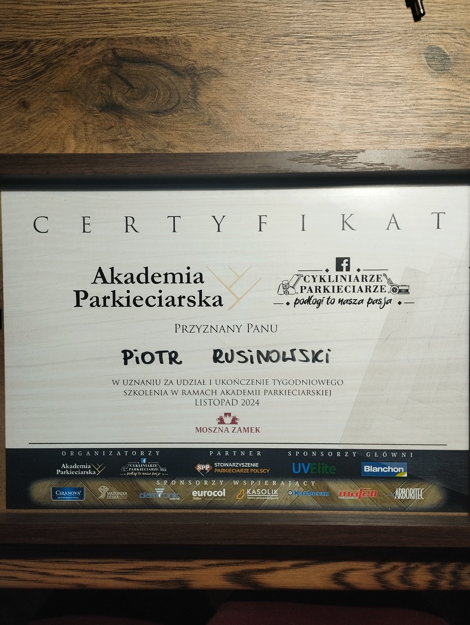 Certyfikat ukończenia szkolenia w Akademii Parkieciarskiej dla Piotra Rusinowskiego, listopad 2024, organizatorzy i sponsorzy, w tym Cykliniarze Parkieciarze z Warszawy.