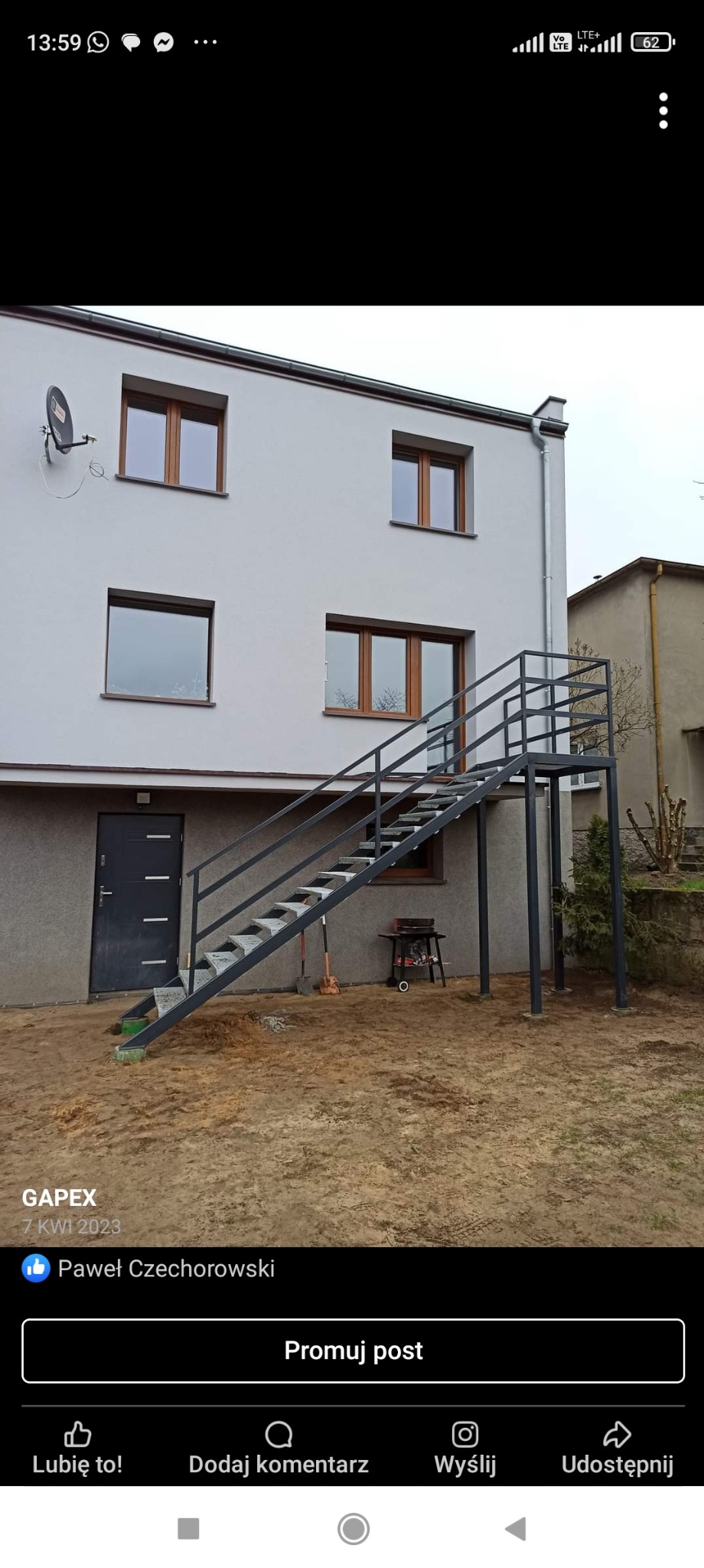 Zewnętrzne schody metalowe prowadzące do drzwi na podwyższeniu, z widocznym grillem i narzędziami na ziemi.