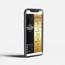 Grafika na ekranie smartfona prezentująca ofertę okolicznościową sklepu z alkoholami Przystań Whisky, z informacjami o indywidualnym podejściu do klienta, przystępnych cenach i szerokim wyborze...