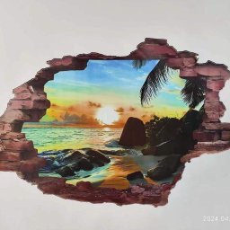 PaintPro Druk Ścienny - Fototapeta 3D imitująca dziurę w ścianie, z widokiem na tropikalną plażę o zachodzie słońca, otoczoną kamieniami i palmą.