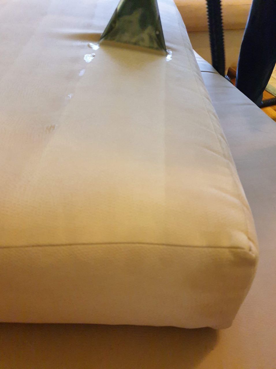 Dysza odkurzacza ekstrakcyjnego czyszcząca jasną tapicerkę kanapy, widoczne ślady wilgoci po czyszczeniu.