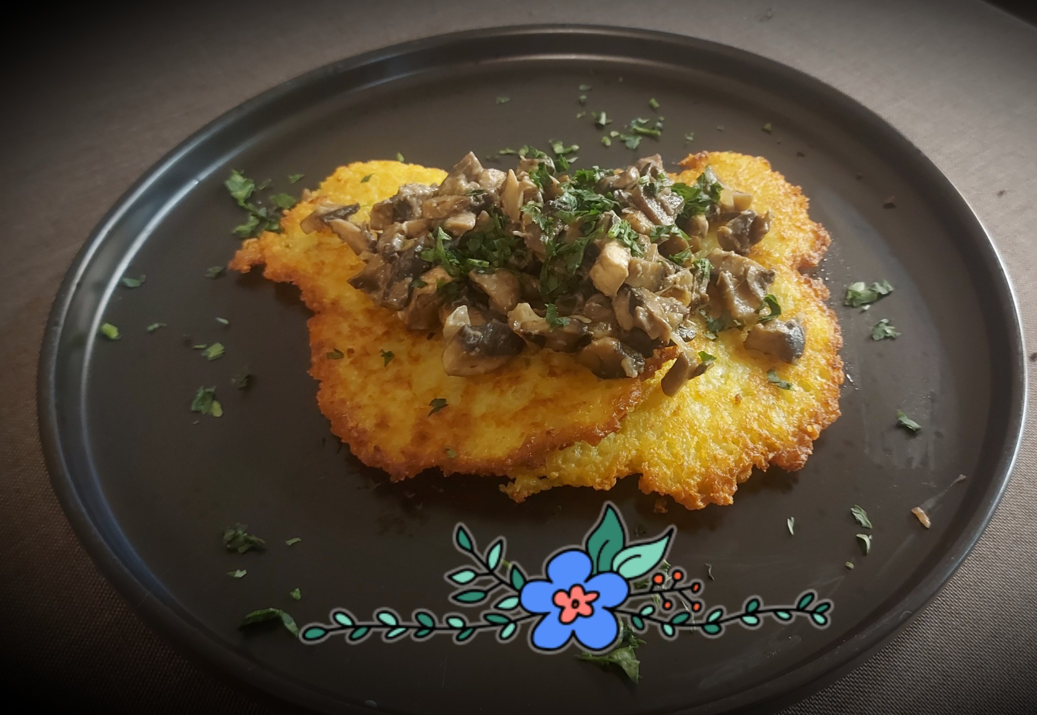 Ziemniaczane placki z sosem grzybowym i posiekaną pietruszką na czarnym talerzu z dekoracyjnym motywem kwiatowym
