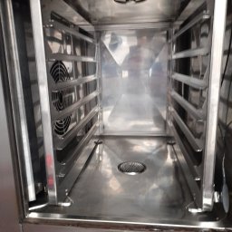 Clean Vibe Bartłomiej Wierzbicki - Wnętrze czystego, nierdzewnego pieca konwekcyjnego z wentylatorem i prowadnicami na blachy, gotowe do użytku.