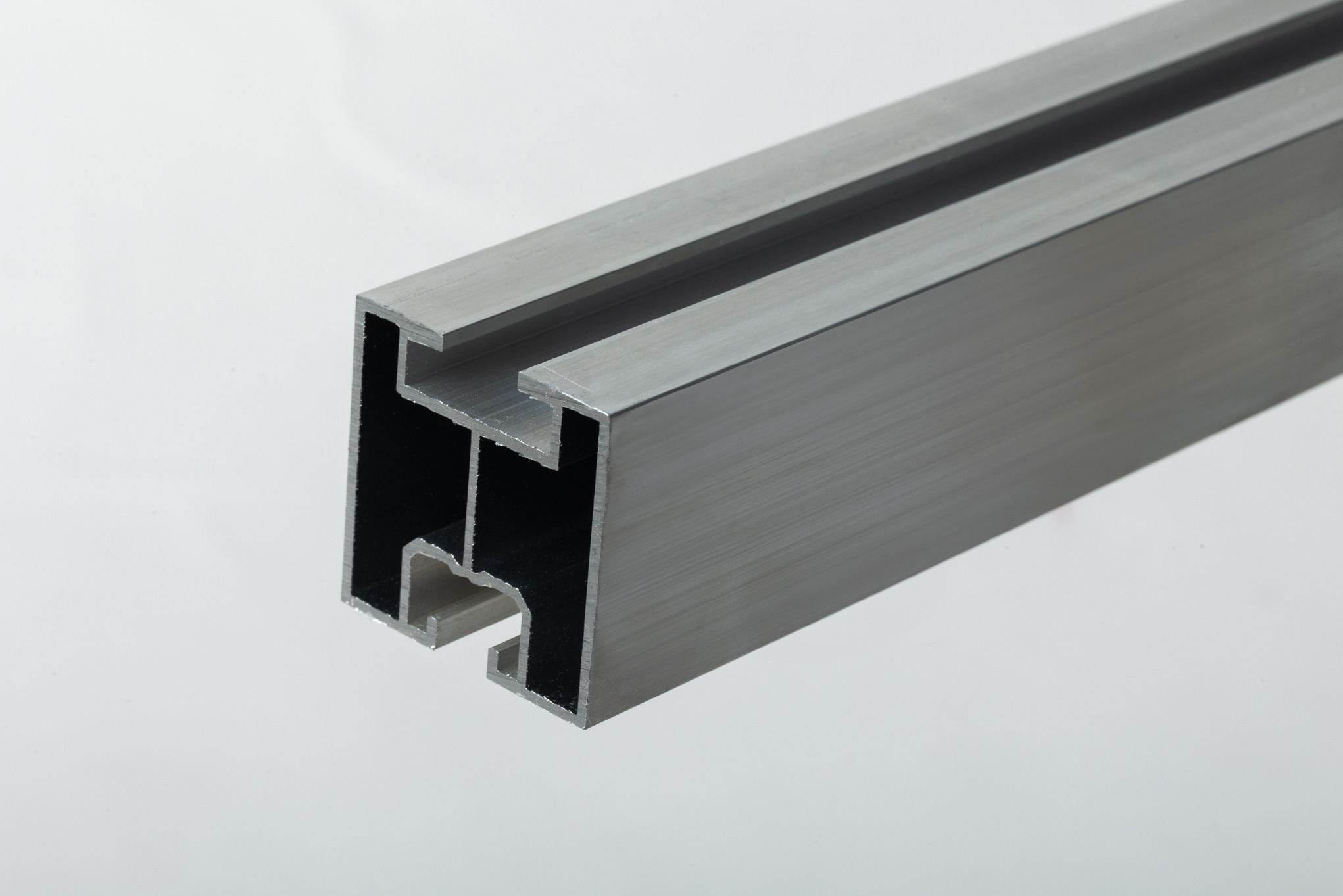 Aluminiowy profil konstrukcyjny z rowkami, potencjalnie do montażu paneli słonecznych, oferowany przez firmę z Nakła nad Notecią. Widoczny przekrój poprzeczny z precyzyjnie wykonanymi wgłębieniami.