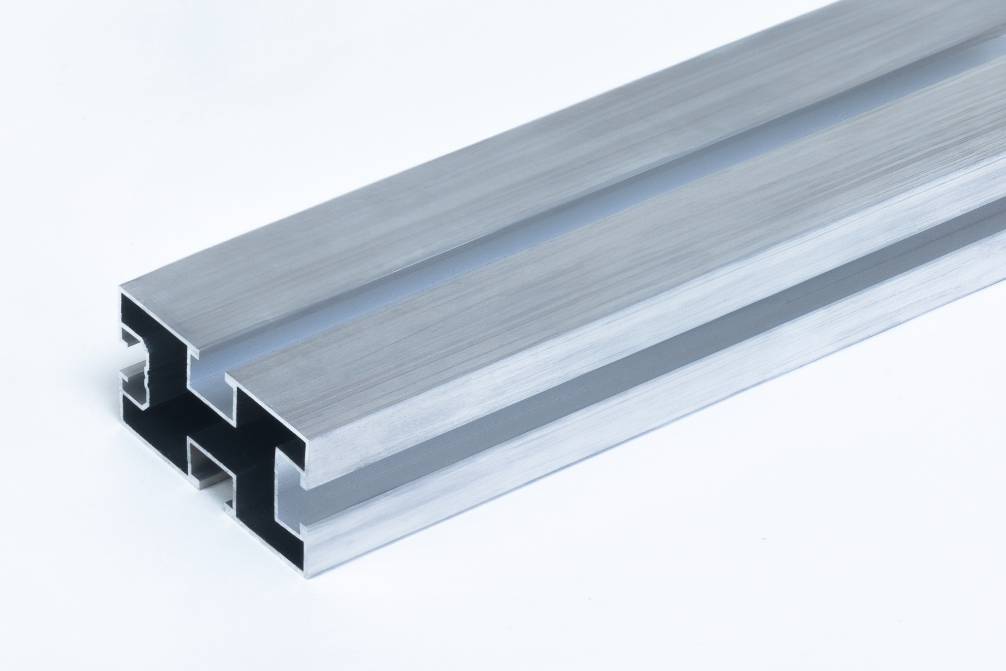 Szlifowany profil aluminiowy o przekroju wielokątnym, widoczny z bliska na białym tle.