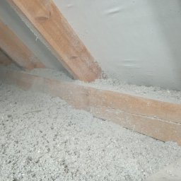 M3 Grażyna Odomirska - Poddasze ocieplone szarą wełną celulozową, widoczne drewniane krokwie i folia paroizolacyjna, oświetlenie naturalne.