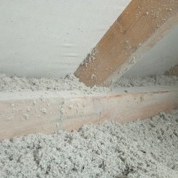 M3 Grażyna Odomirska - Poddasze z drewnianą konstrukcją krokwiową wypełnione szarą wełną celulozową, widoczna membrana paroizolacyjna na górze.