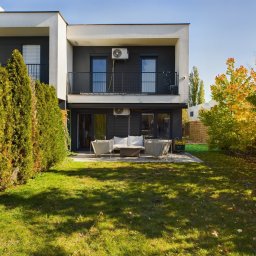 CARBON ESTATE - Nowoczesny, dwukondygnacyjny dom z ogrodem w Chorzowie, z balkonem i tarasem. Widoczne krzewy i drzewa w jesiennych barwach. Minimalistyczny design.