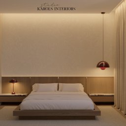 Karols Interiors - Minimalistyczna sypialnia z łóżkiem na drewnianej platformie, lampkami nocnymi z czerwonymi kloszami i teksturowaną ścianą z subtelnym oświetleniem LED.