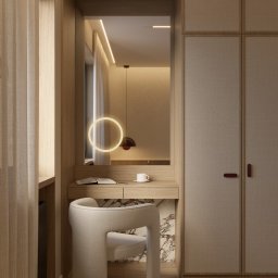 Karols Interiors - Toaletka z lustrem podświetlanym okręgiem, tapicerowane szafy wnękowe i krzesło boucle w neutralnej kolorystyce wnętrza.