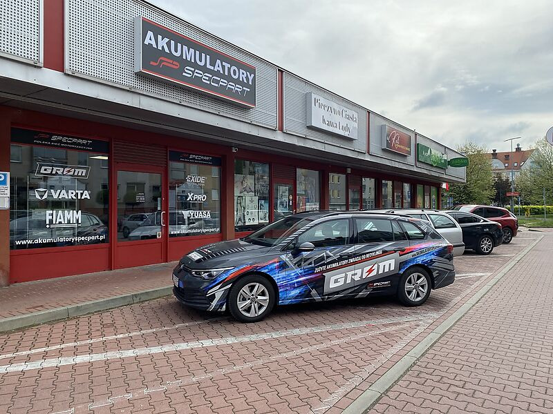 Sklep z akumulatorami Specpart z reklamą na samochodzie firmowym, marki Varta, Exide, Yuasa i FiAMM.