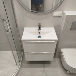 Serra's team Zakład Budowlany Rafał Serafin - Nowoczesna łazienka w jasnych odcieniach: kabina prysznicowa ze srebrnymi okuciami, biała umywalka z szafką i okrągłe lustro z podświetleniem LED.