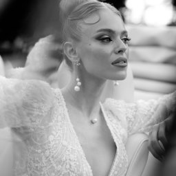 My Little White Studio - Czarno-białe, portretowe ujęcie kobiety w bogato zdobionej, koronkowej sukni z głębokim dekoltem, z perłowymi kolczykami i naszyjnikiem, włosy upięte w kok, wzrok skierowany w prawo, siedzącej...