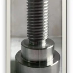 Metalowy element z gwintem, składający się z trzech cylindrycznych części o różnej średnicy, sfotografowany na jasnym tle.