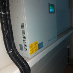 Przedsiębiorstwo Pomiarów i Automatyzacji Advanced Solutions inż. Adam Gawlik - Szary moduł Advanced Static Var Generator marki Sinexcel umieszczony na białej półce, z widocznymi czarnymi rurami karbowanymi po lewej stronie i etykietami ostrzegawczymi na obudowie.