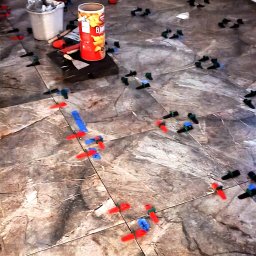 GAMB-POL - Układanie płytek podłogowych z użyciem systemu poziomowania w Świebodzicach. Widoczne narzędzia, płytki imitujące marmur i cień osoby na ścianie.