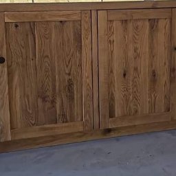 Holleywood - Ręcznie robiona szafka z litego drewna z czterema drzwiczkami i otwartą półką po prawej stronie, widoczne naturalne usłojenie drewna i ciemne, okrągłe uchwyty.