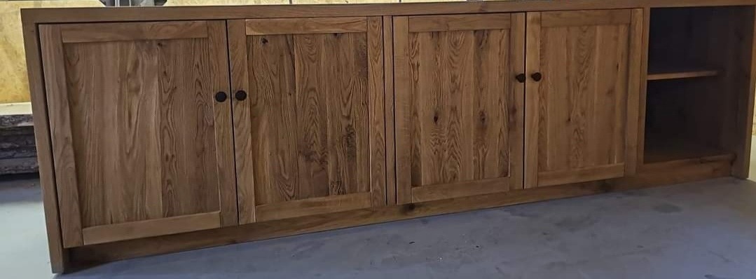 Ręcznie robiona szafka z litego drewna z czterema drzwiczkami i otwartą półką po prawej stronie, widoczne naturalne usłojenie drewna i ciemne, okrągłe uchwyty.