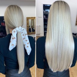 Marlena Tomczyk Hair Design - Porównanie przedłużonych, platynowych włosów blond: z tyłu związane białą apaszką w brązowe listki oraz rozpuszczone, proste, sięgające do połowy pleców.