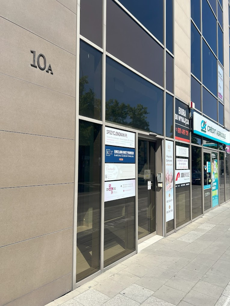 Fasada budynku biurowego z numerem 10A, widoczne szyldy różnych firm, w tym gabinetu poradnictwa żywieniowego z informacjami kontaktowymi.