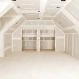 Poddasze w trakcie zabudowy płytami gipsowo-kartonowymi; widoczne stelaże i przygotowane wnęki.