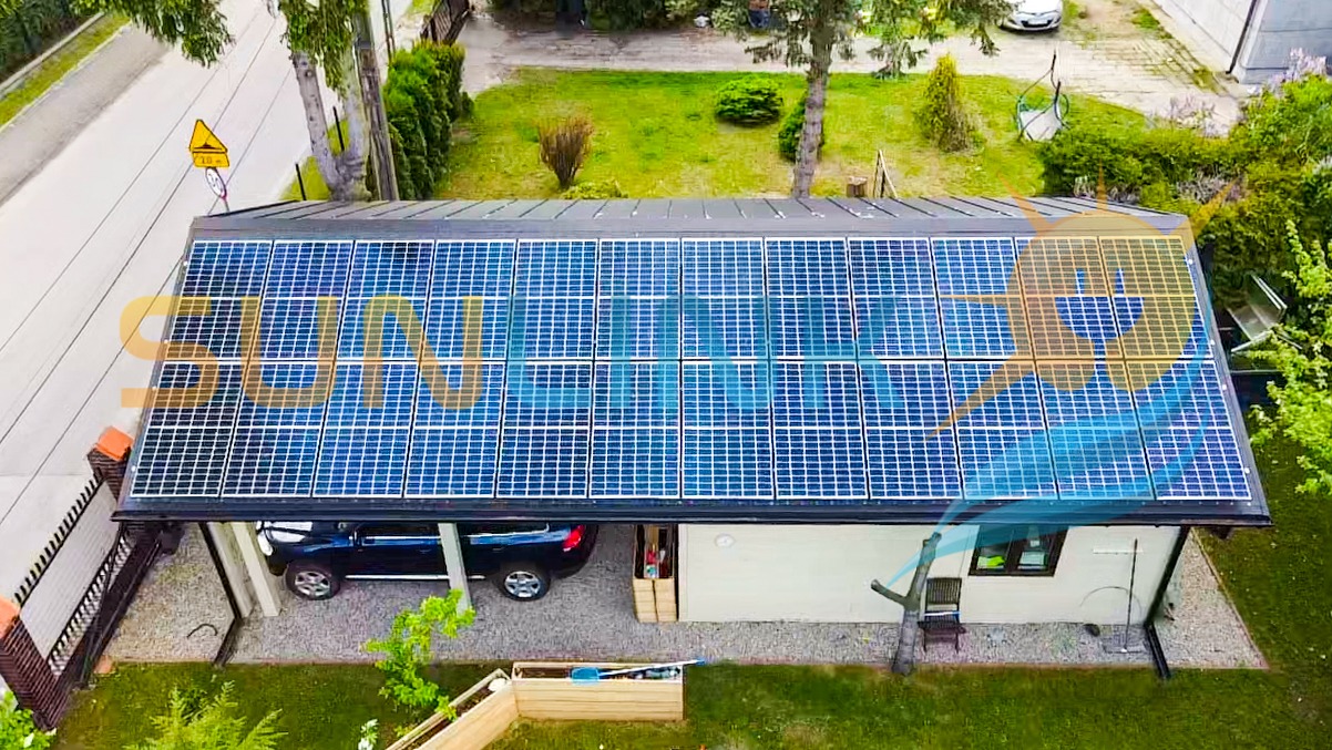 Instalacja paneli słonecznych na dachu garażu z wjazdem dla samochodu, widok z góry, otoczenie zieleni, dom jednorodzinny.