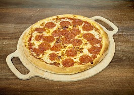 Okrągła pizza pepperoni z rumianymi brzegami na drewnianej desce z uchwytami, ułożona na blacie o fakturze drewna.