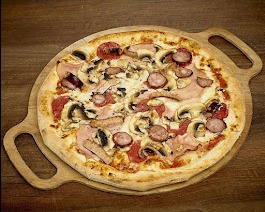 Okrągła pizza z pieczarkami, szynką i kiełbasą pepperoni, ułożona na drewnianej desce z uchwytami na tle drewnianego stołu.