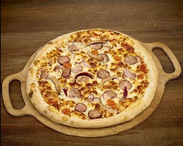 Apetyczna pizza z kiełbasą, cebulą i pomidorami na drewnianej desce do serwowania z uchwytami.