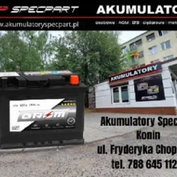 Czarny akumulator samochodowy marki Grom na tle budynku sklepu z akumulatorami Specpart w Koninie.