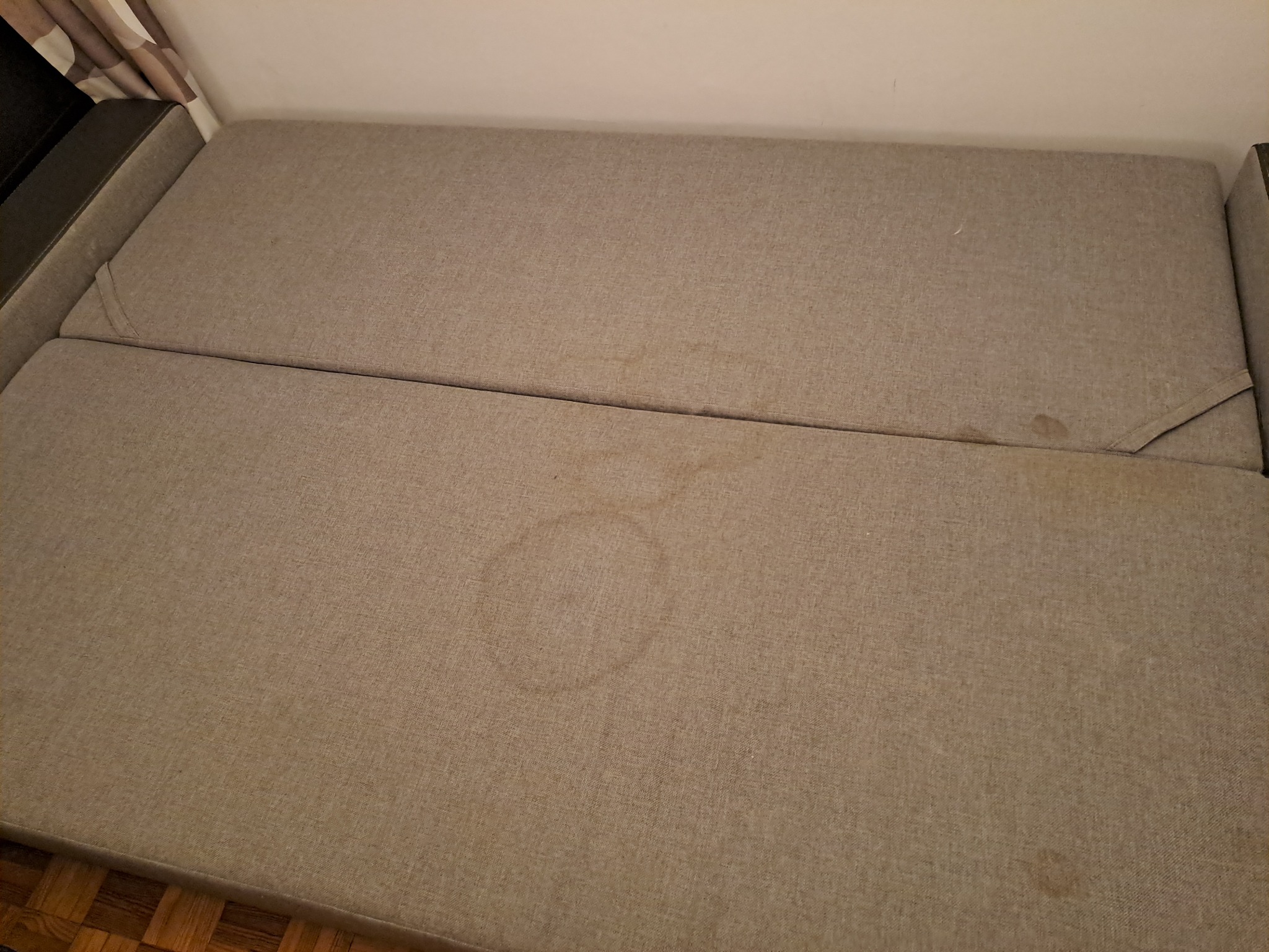 Beżowa kanapa z plamami na siedzisku, widok z góry.