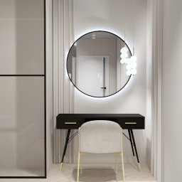 Trans - Hurt Sp. J. - Nowoczesna łazienka z czarną toaletką, okrągłym lustrem z podświetleniem LED, designerską lampą wiszącą i krzesłem w kolorze ecru na parkiecie w jodełkę.