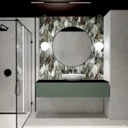 Nowoczesna łazienka z kabiną prysznicową typu walk-in, okrągłym lustrem na tle tapety w motywy liści, umywalką nablatową i zieloną szafką pod umywalką.