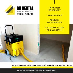 DH Rental - Osuszanie, lokalizacja wycieków, pomiary wilgotności, ozonowanie, wynajem osuszaczy - Żółto-czarny osuszacz kondensacyjny Trotec z podłączonymi żółtymi wężami, na tle częściowo osuszonego, surowego pomieszczenia po zalaniu, obok reklama firmy DH Rental oferującej wynajem osuszaczy...