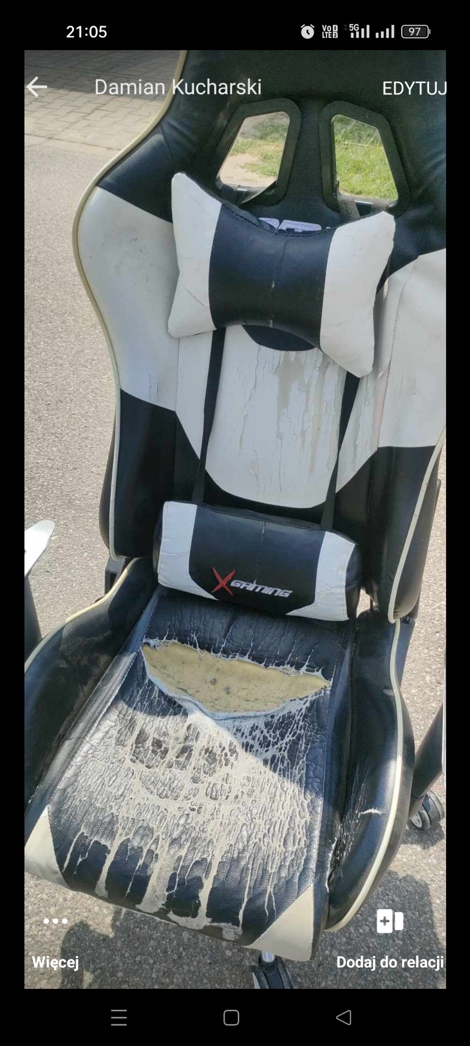 Zużyte, czarno-białe krzesło gamingowe z widocznymi śladami intensywnego użytkowania i uszkodzeniami tapicerki.