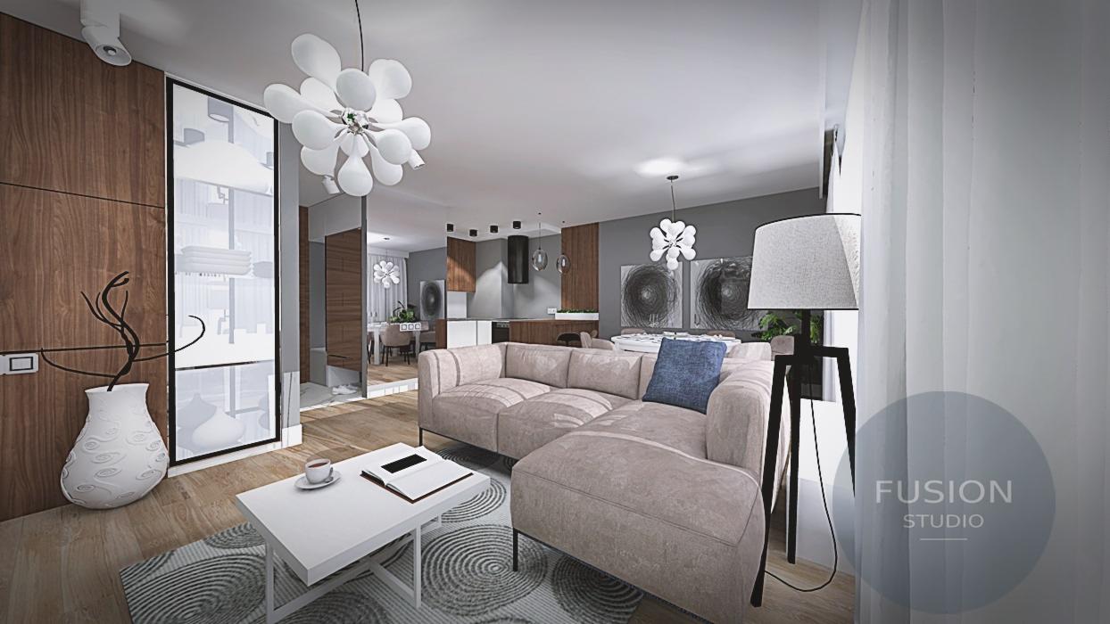 Jasny salon z narożną sofą w odcieniach beżu, biały stolik kawowy z książką i filiżanką, nowoczesna lampa stojąca oraz dekoracyjny wazon z suchymi gałązkami, widok na otwartą kuchnię i jadalnię.