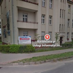 BartekDera.pl - Usługi Informatyczne i Edukacja mgr inż. Bartłomiej Dera - Budynek z szyldem 'BartekDera.pl Usługi Informatyczne', widok z ulicy, dzień.