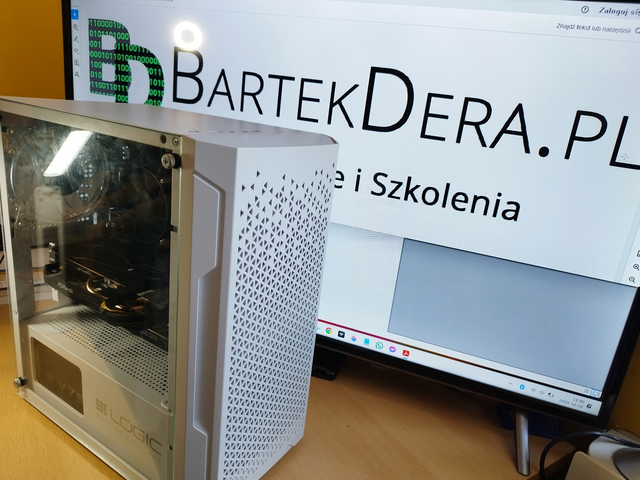 Biała obudowa komputera stacjonarnego marki Logic z widocznymi podzespołami wewnątrz, na tle monitora wyświetlającego stronę internetową z adresem BartekDera.pl i ringiem LED na górze monitora.