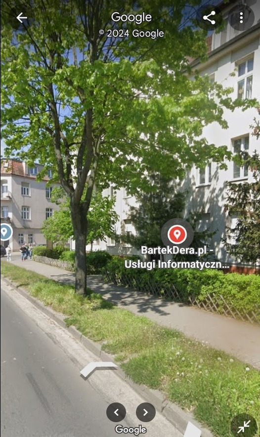 Budynek firmy informatycznej z widocznym adresem BartekDera.pl, otoczony zielenią, sfotografowany z poziomu ulicy.