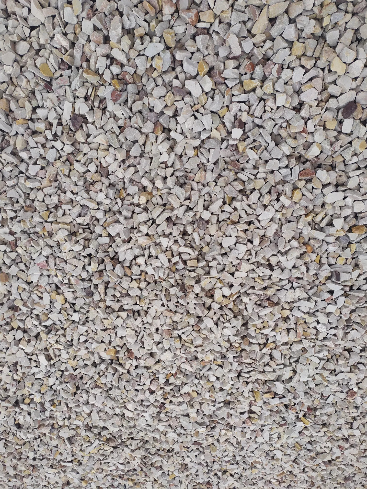 Drobny, jasnoszary żwir z domieszką beżowych i rdzawych kamyczków, tworzący równomierną powierzchnię.